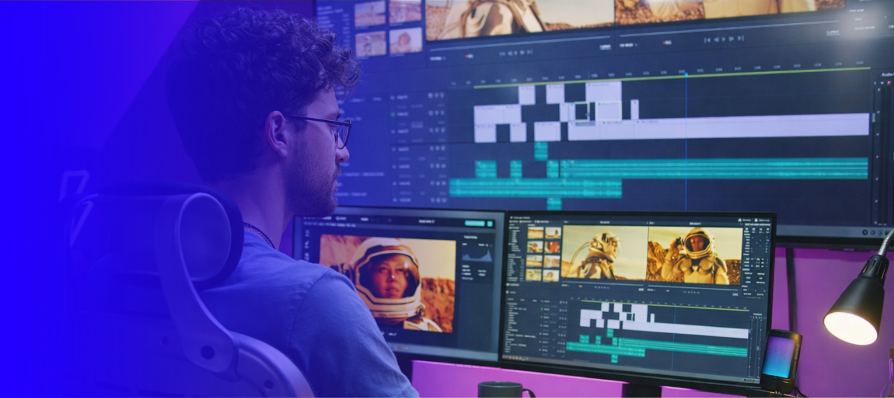 A video editor sits at a workstation reviewing footage and timelines across multiple monitors. The screens display a video editing interface with clips, color grading, and a detailed timeline, including scenes featuring astronauts in a desert landscape. A blue-to-purple gradient overlays the left side of the image, giving the scene a stylized, modern look and suggesting the post-production stage of an AI video production workflow.