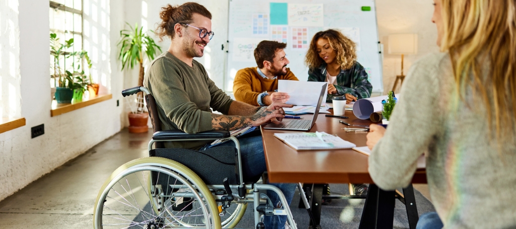 man in wheelchair working at the office