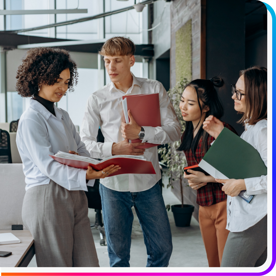 Group of four creative recruiters in modern office looking at a document at creative staffing agency