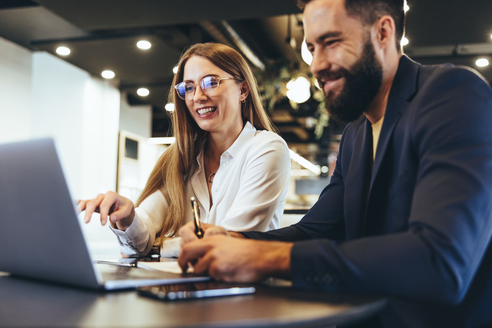 Two gaming experts looking at laptop screen at gaming & extended reality staffing firms