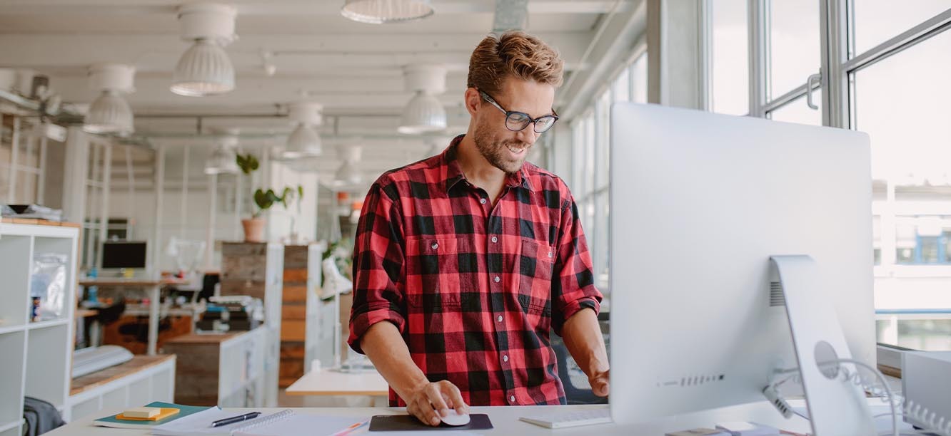 Creative professional standing at computer looking for creative jobs in Charlotte, NC