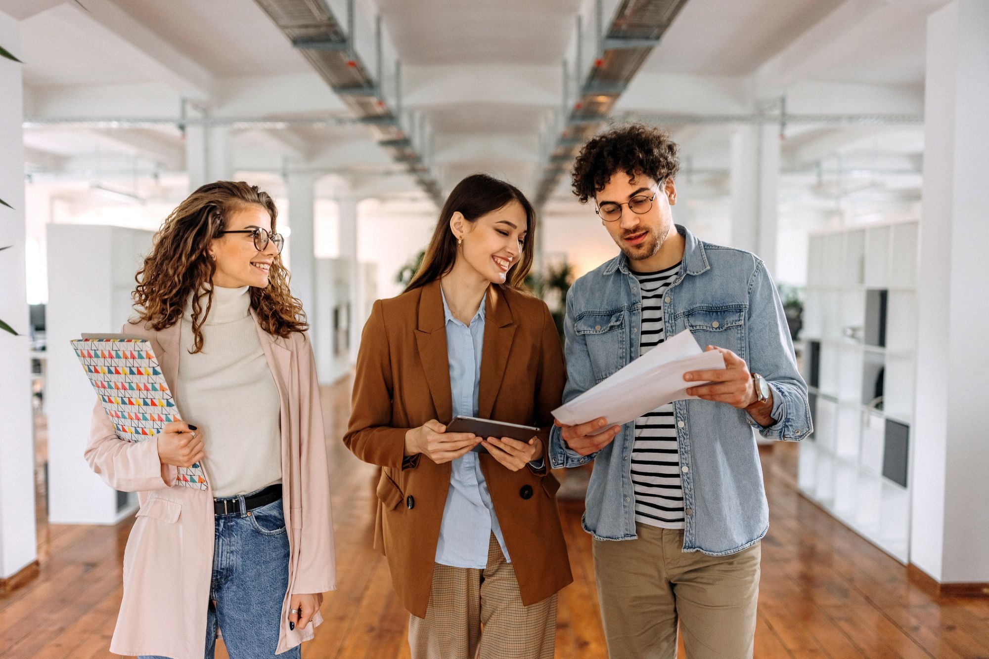 Three digital accessibility experts walking in modern staffing and talent solutions office