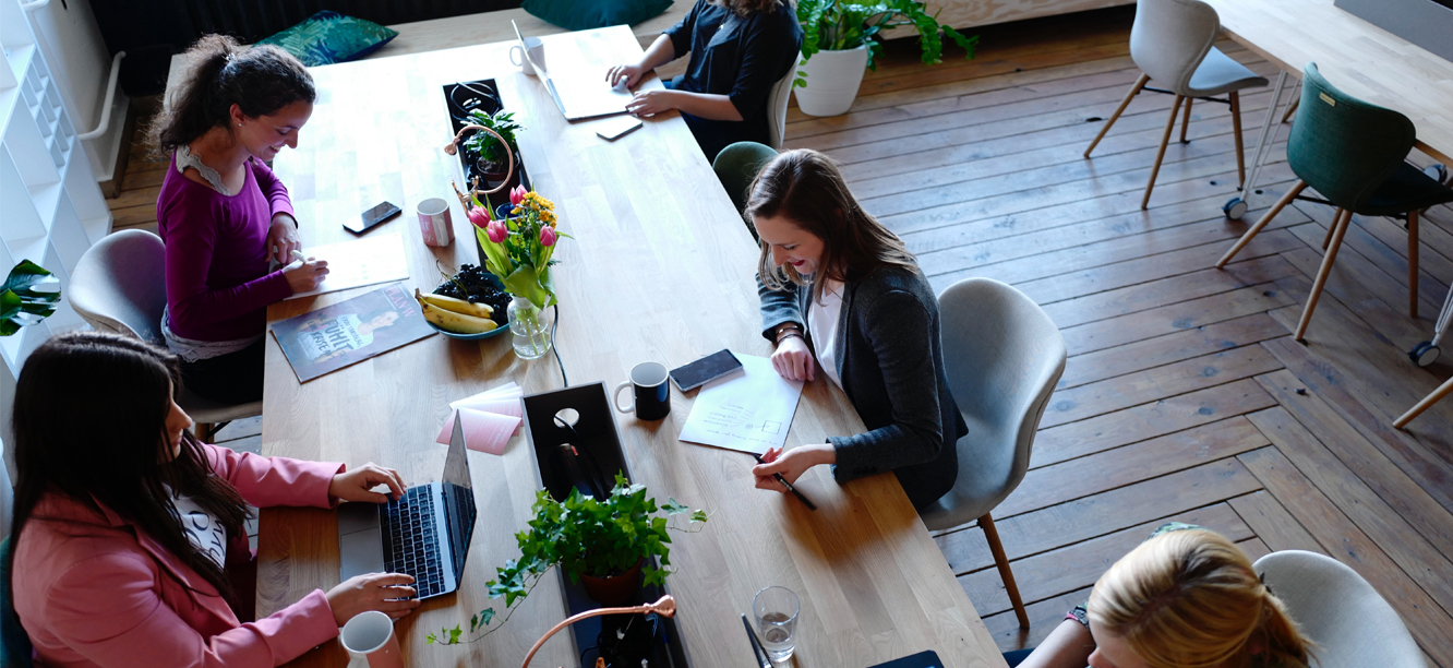 Birds eye view of Onward Search staffing and talent solutions employees working at long table, reviewing contact us form