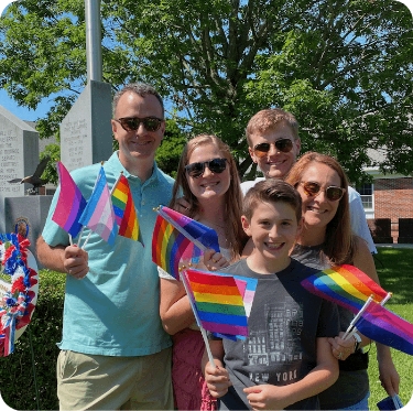 Onward Search CEO Ken Clark and family holding up Pride flags for diversity, equity, and inclusion